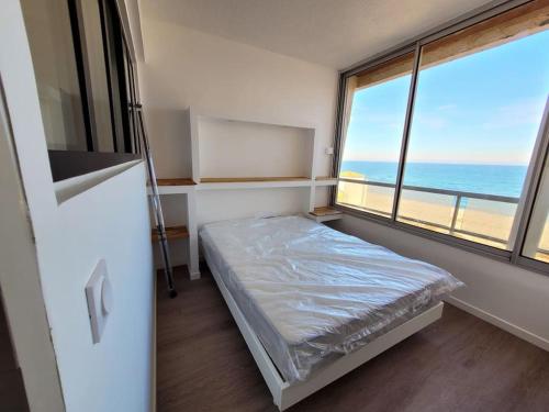 Cette petite chambre comprend un lit et une grande fenêtre. dans l'établissement Vue mer exceptionnelle, au Barcarès