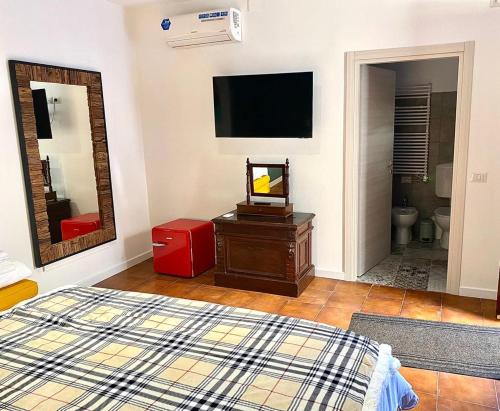 a bedroom with a bed and a tv on the wall at Da li Poteri in Colfiorito