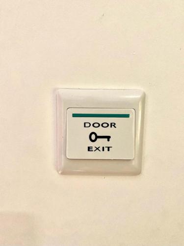 a door exit sign on a white wall at Da li Poteri in Colfiorito