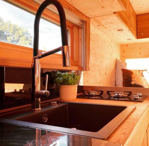 a kitchen with a sink in a wooden kitchen at Zinipi Lodge am Oldtimer auf Demeterhof Michlbauer in Ursensollen