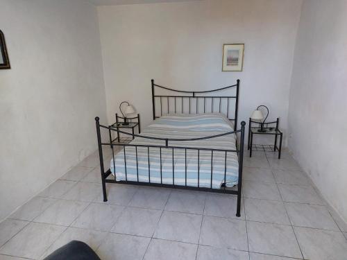 1 dormitorio con 1 cama y 2 mesitas de noche en Le Gite, en Labastide-de-Virac