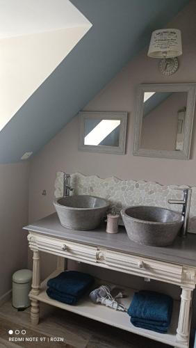 dos lavabos en la parte superior de un mostrador en un baño en Les chambres de l'Atelier, en Pont-Aven