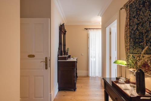 a hallway with a door and a table and a mirror at Quinta do Outeiro in Resende