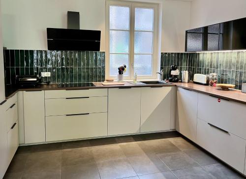 a kitchen with white cabinets and a window at Centre ville Haguenau - 5pers in Haguenau