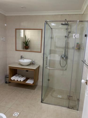 a bathroom with a shower and a sink at Beau Séjour Hotel in Victoria