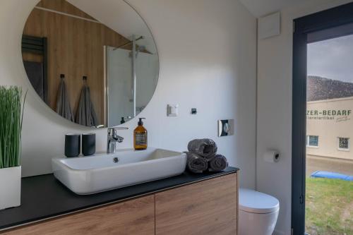 a bathroom with a sink and a mirror at Velo & Wohnen -NEU- Elektroräder inklusive-Sauna-Moselblick in Enkirch