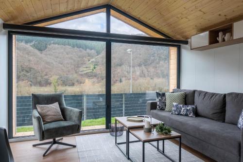 a living room with a couch and a large window at Velo & Wohnen -NEU- Elektroräder inklusive-Sauna-Moselblick in Enkirch