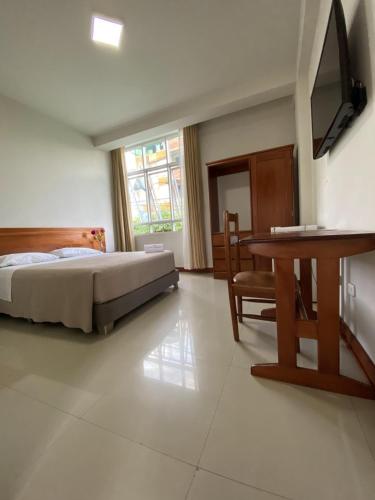 sypialnia z łóżkiem, stołem i biurkiem w obiekcie Hotel Peru Amazonico w mieście Puerto Maldonado