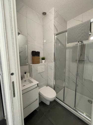une salle de bain blanche avec toilettes et douche dans l'établissement Studio à deux pas de la mer, à Nice