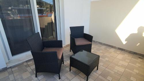 two chairs and a table in a room at Ma Maison Bleue in Kremasti