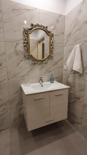 a bathroom with a sink and a mirror on a wall at Ma Maison Bleue in Kremasti