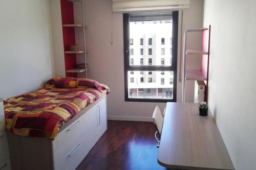 - une chambre avec un lit, une table et une fenêtre dans l'établissement Grande, luminoso y con garage, 3 dormitorios en el camino de Santiago, à Burgos