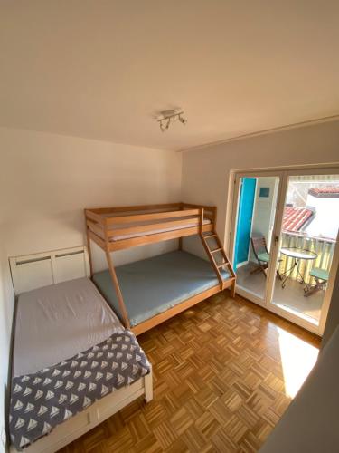 a bedroom with a bunk bed and a balcony at Lucy Apartment Piran-Punta in Piran