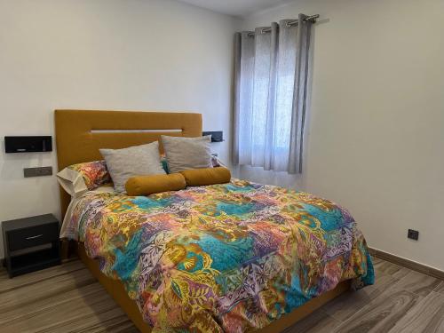- une chambre avec un lit et une couette colorée dans l'établissement Alamos Suite, à Jaén
