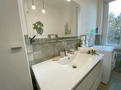 a white bathroom with a sink and a washer at Villa Boeddu, relax tra mare e campagna in Alghero