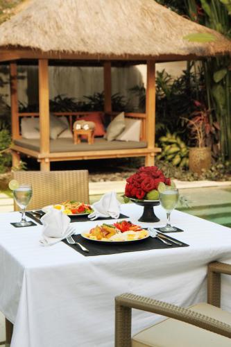 a table with two plates of food on top at Villa Bali Asri Batubelig in Seminyak