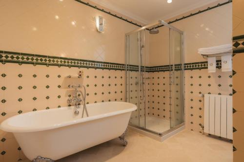 a bathroom with a shower and a white tub at Quinta do Outeiro in Resende