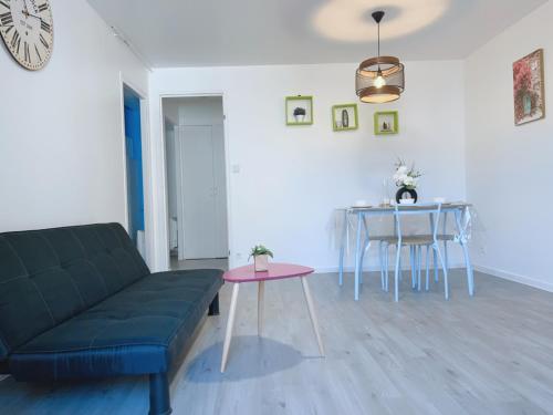 a living room with a couch and a table at Apt 67m2 hyper centre: 2 chambres, cuisine TV wifi in Fontenay-le-Comte