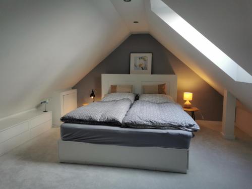 a bedroom with a white bed in a attic at Apartment Luise in Friedrichskoog