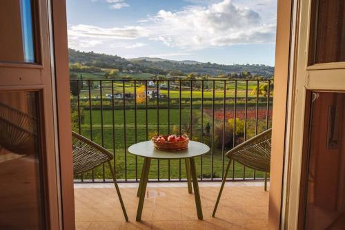 a table with a bowl of fruit on a balcony at Casa di nonna in Bevagna