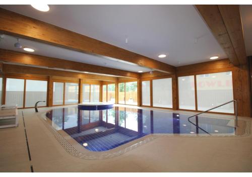 a large indoor swimming pool in a building with windows at Apartman 22, Rezidence & Wellness Javor in Železná Ruda