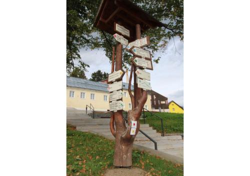 a tree with signs on it with a bird house at Studio Apartman 22, Rezidence Javor in Železná Ruda