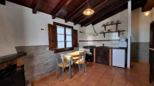 a kitchen with a table and chairs in a room at La Casina de la Huerta in Llanes