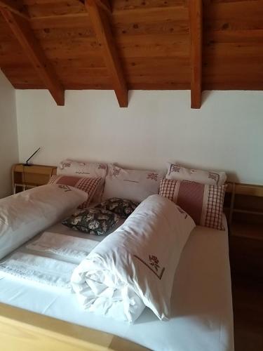 a bed with pillows on it in a room at Alpin Ranch in Zărneşti