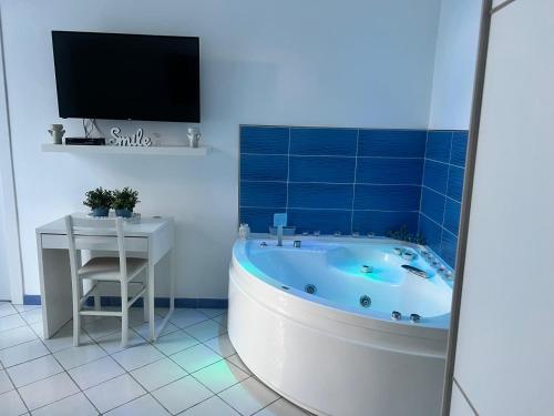 a bathroom with a tub and a television in it at Riva Destra Suite apartament in Ischia