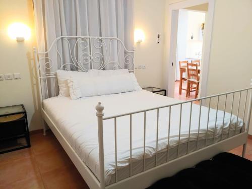 Cama en habitación con marco de cama blanco en Spot in the Village פינה במושב, en Livnim