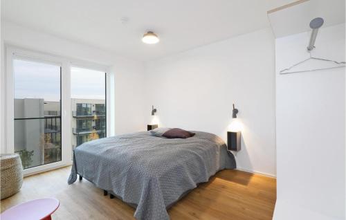 ein weißes Schlafzimmer mit einem Bett und einem großen Fenster in der Unterkunft Penthouse Comfort in Lembruch