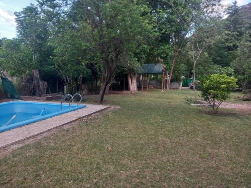 un patio con piscina y un patio con árboles en El quincho en Las Padercitas