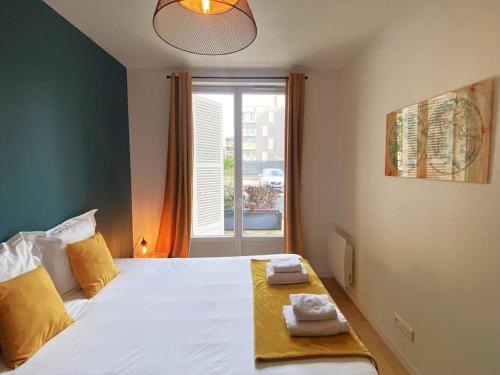 a bedroom with a bed with yellow pillows and a window at White House - THE SUNNY avec TERRASSE et PARKING privé - 20 min CENTRE in Amiens