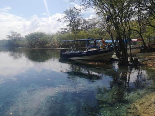 a man is standing on a boat in the water at Hotel Colibrí Petén in Santa Elena