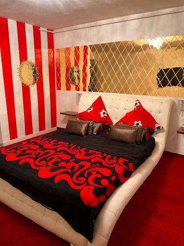 um quarto com uma cama grande com riscas vermelhas e brancas em Garsoniera Mihaela em Deva