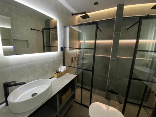 a bathroom with a sink and a glass shower at Celestial Luxury SKG Port in Thessaloniki