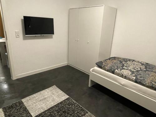 Kleines Zimmer mit einem Bett und einem Flachbild-TV. in der Unterkunft Ferienwohnung Nähe Hbf Bremerhaven in Bremerhaven