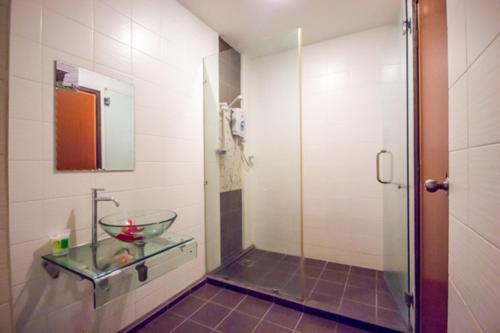 La salle de bains est pourvue d'un lavabo en verre et d'une douche. dans l'établissement Chariton Hotel Butterworth, à Butterworth