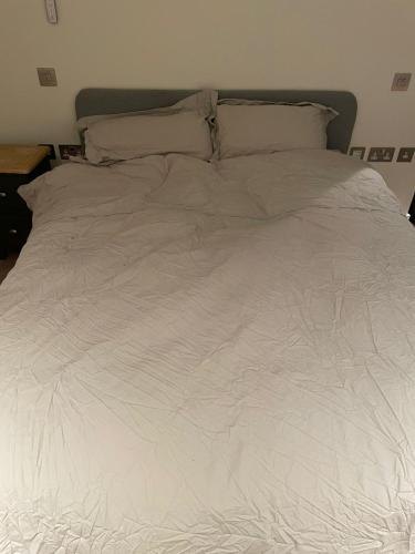 a white bed with white sheets and pillows at The AA WIFI in London