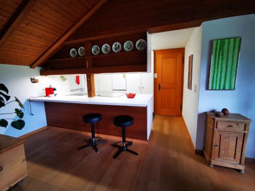 - une cuisine avec un comptoir et deux tabourets dans l'établissement Marmottin, à Lucerne