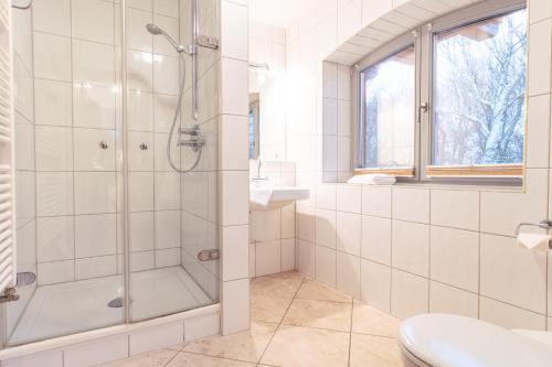 a white bathroom with a shower and a sink at Dünenhof DÜNENHOF Whg. D-10 in Wustrow