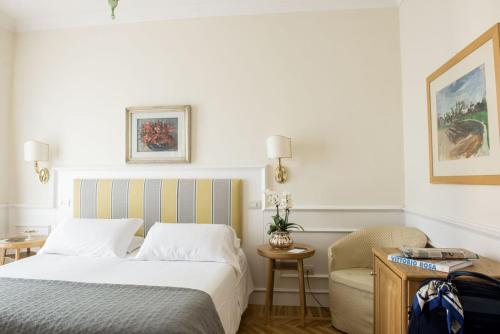 a hotel room with a bed and a chair at Hotel Royal in Stresa