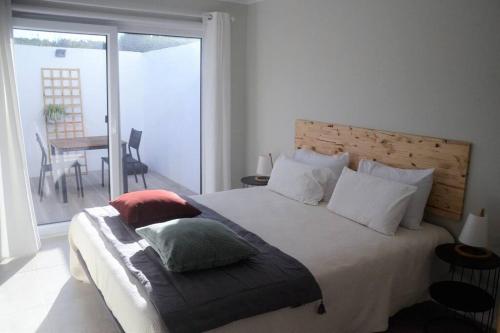 Un dormitorio con una cama grande con almohadas. en Cantinho do Pópulo en Ponta Delgada