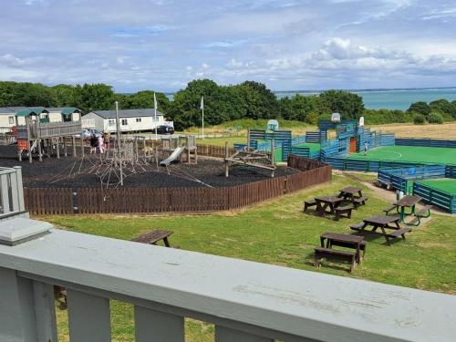 un parque con parque infantil con mesas y bancos en luxury new 3 bed caravan with stunning sea view on private beach in Thorness bay, en Porchfield