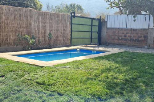 uma piscina num quintal ao lado de uma cerca em CABAÑA PARA RELAX EN OLMUE em Valparaíso