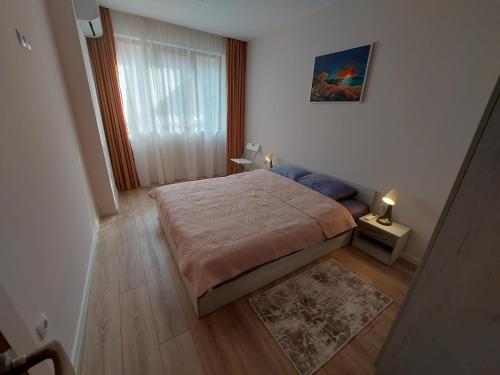 a small bedroom with a bed and a window at White grapes apartment in Petrich