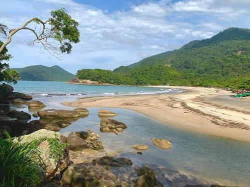 una playa con rocas y el océano y las montañas en Casa da Floresta entre Paraty e Ubatuba en Ubatuba