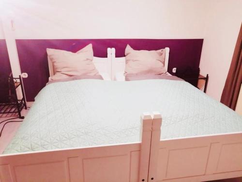 ein großes Bett mit weißer Bettwäsche und Kissen in der Unterkunft Ferienwohnung Monteurzimmer in Plessa