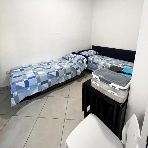 a room with two beds and a table in it at ELISA Dependance Centro in Vietri sul Mare