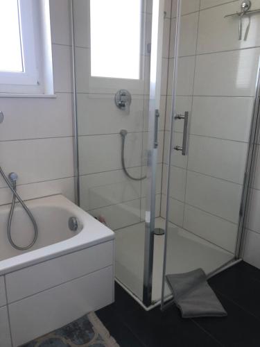 ein Badezimmer mit einer Dusche, einer Badewanne und einem Waschbecken in der Unterkunft Zentrales City Penthouse in Friedrichshafen